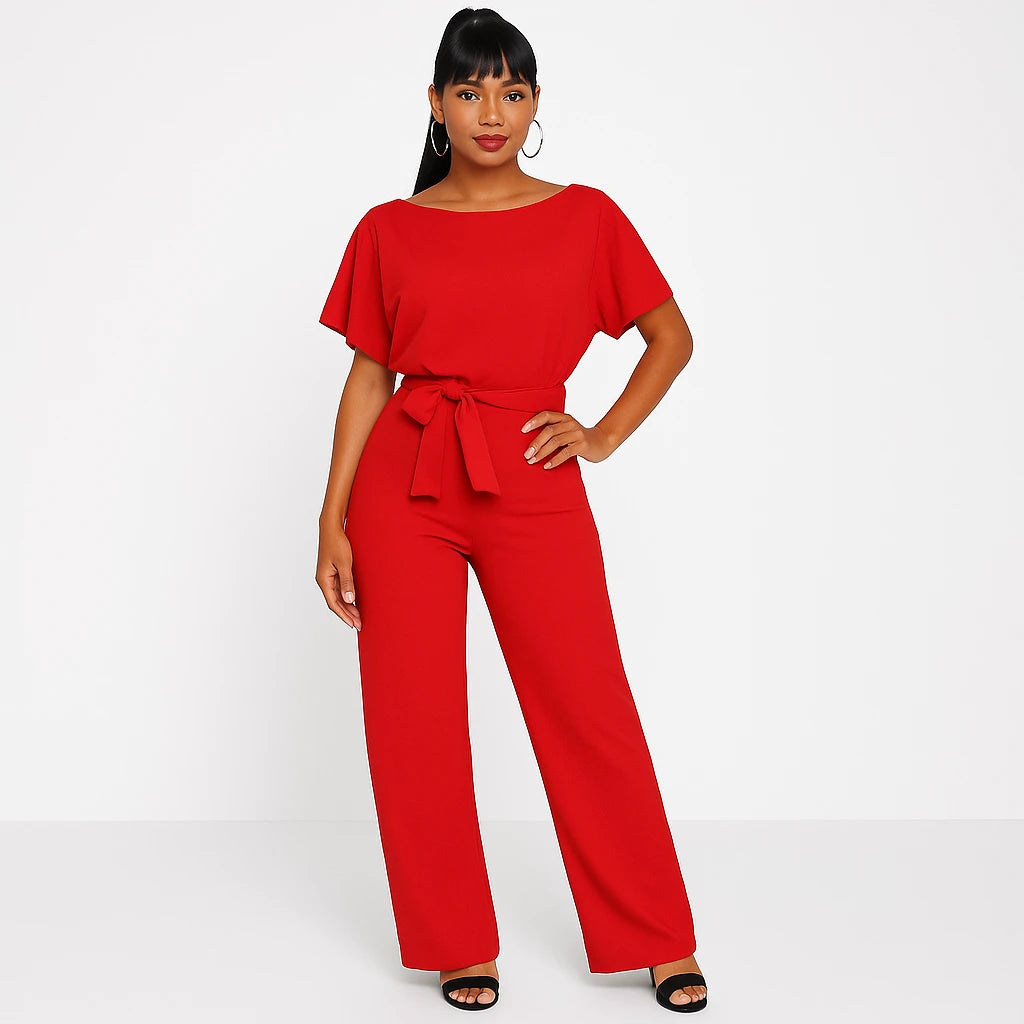 Woman wearing a red ponte knit batwing jumpsuit - studio photo