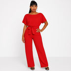 Woman wearing a red ponte knit batwing jumpsuit - studio photo