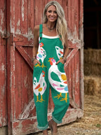 Woman in a teal-green rooster print jumpsuit standing by a red barn door
