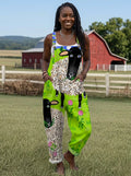 Woman wearing a green sheep and floral print sleeveless wide-leg overall jumpsuit standing in a farm field