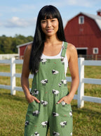 Woman wearing a green jumpsuit with a white sheep print on a farm