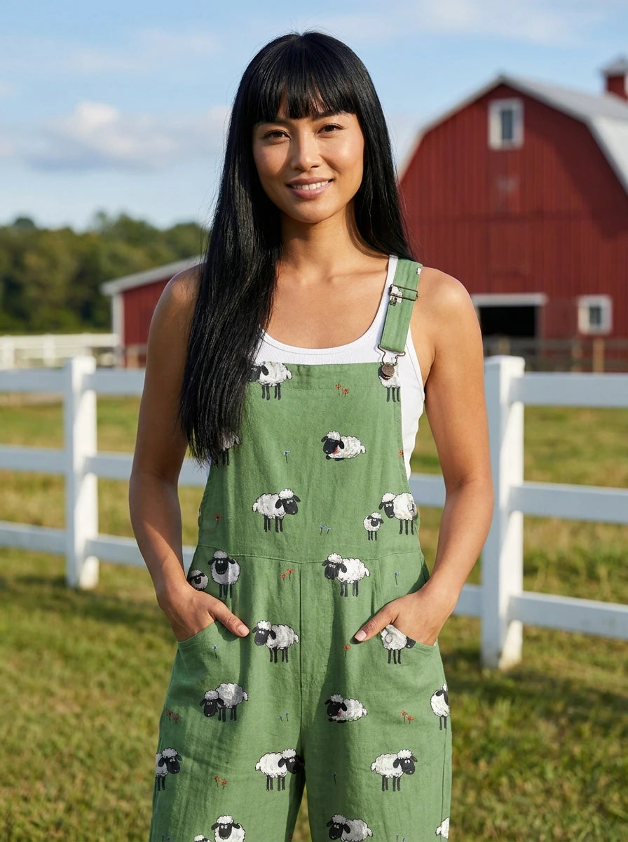 Woman wearing a green jumpsuit with a white sheep print on a farm