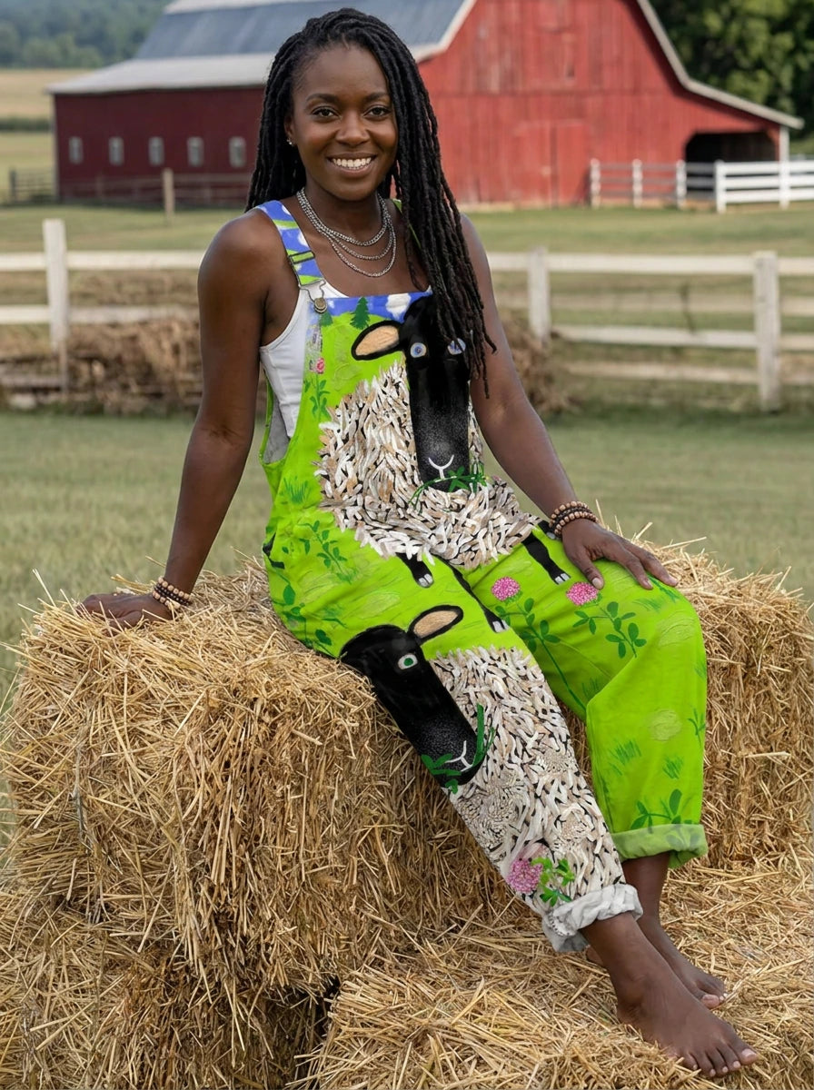 Woman wearing a green sheep and floral print sleeveless wide-leg overall jumpsuit sitting on hay bales