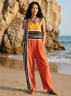 Woman wearing a striped color-block jumpsuit on a beach
