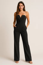 Woman wearing a black strapless tuxedo jumpsuit - studio photo