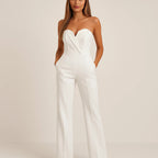 Woman wearing a white strapless tuxedo jumpsuit - studio photo