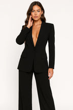 Woman wearing a black stretch crepe two-piece jumpsuit - studio photo