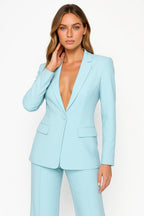 Woman wearing a light blue stretch crepe two-piece jumpsuit - studio photo