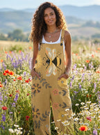 Woman wearing a tan-mustard jumpsuit with a bee and floral print in a flower field
