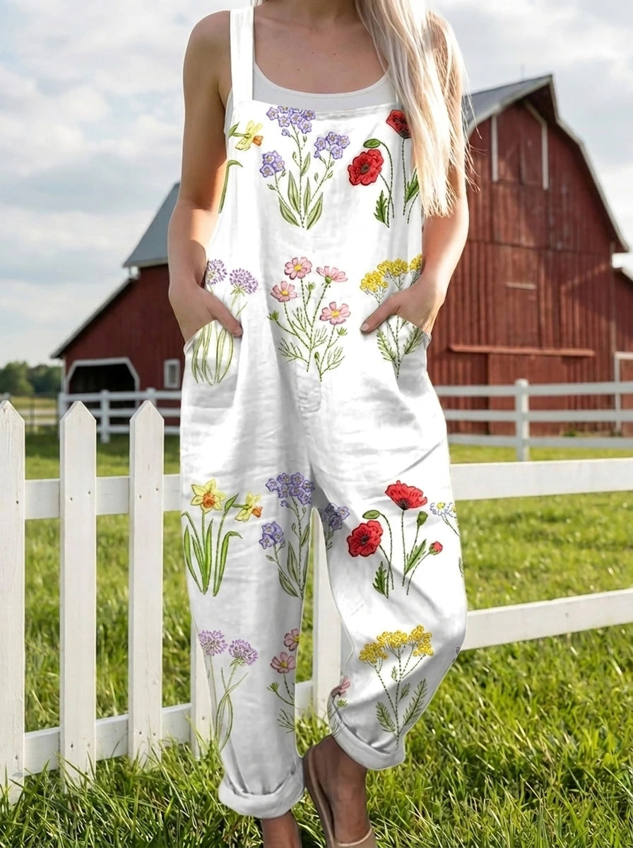 Woman standing near a white picket fence wearing a wildflower print jumpsuit