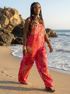 Woman walking on a beach wearing a wildflower print wide-leg jumpsuit