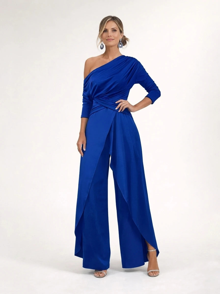 Driftly blue asymmetrical one-shoulder jumpsuit with crossed detail and flowing wide-leg trousers, in a minimalist studio setting with soft window light.