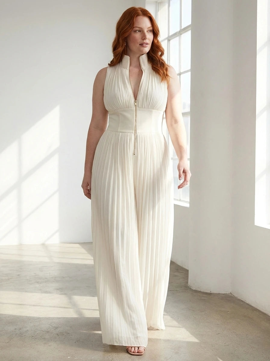 Woman wearing a white pleated sleeveless jumpsuit in a bright minimalist interior