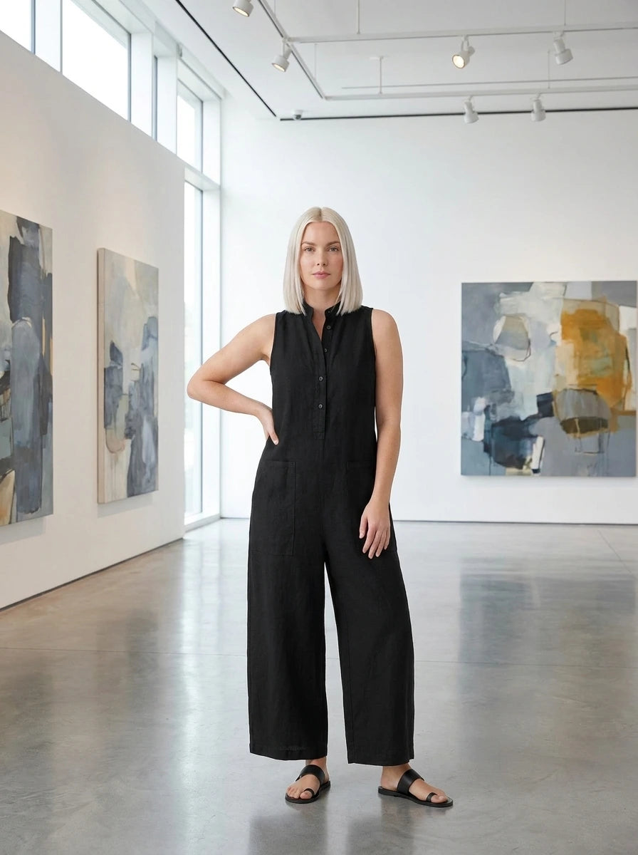 Woman wearing a black sleeveless minimalist jumpsuit in a modern art gallery