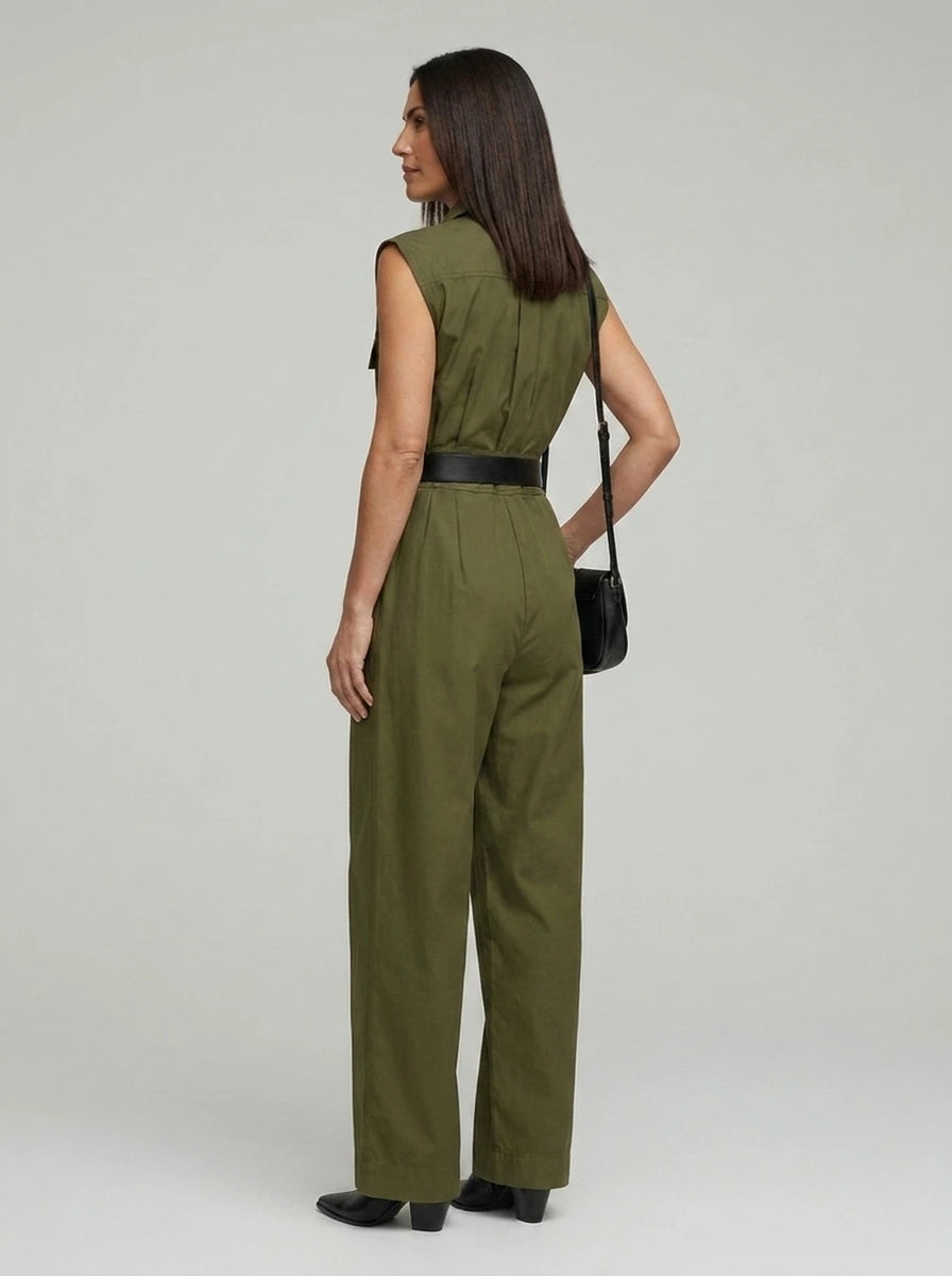 Back view of woman wearing an olive sleeveless utility jumpsuit, studio shot