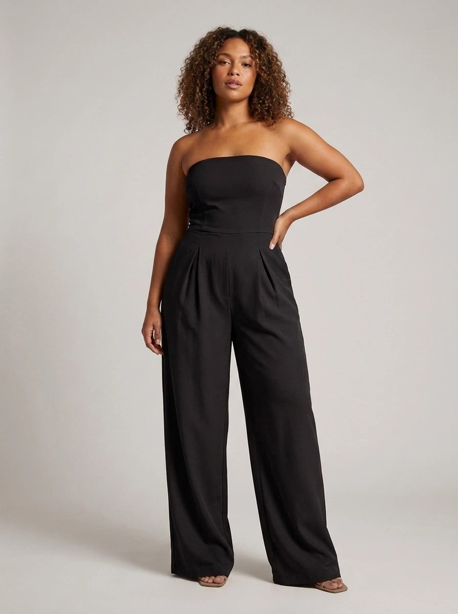 Woman wearing a black strapless wide-leg jumpsuit with fitted top, studio shot