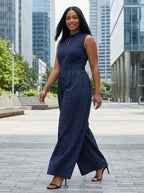 Woman wearing a dark blue striped wide-leg jumpsuit in a city plaza