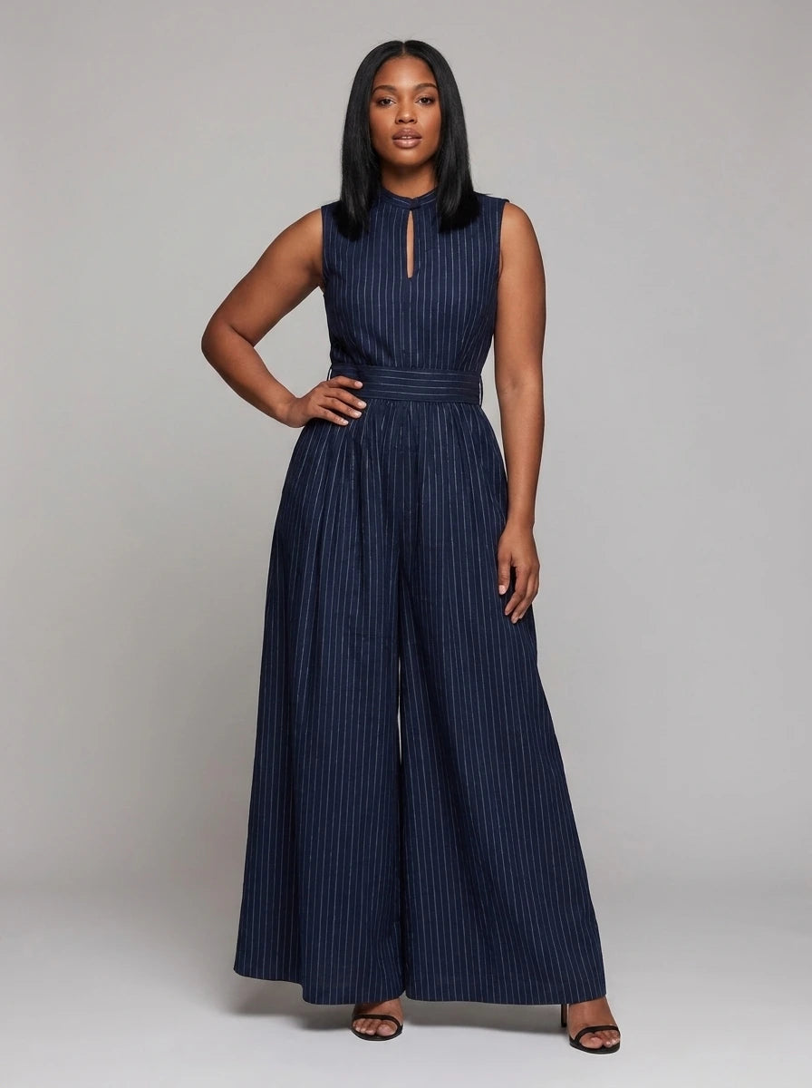 Woman wearing a dark blue striped wide-leg jumpsuit with high collar, studio shot