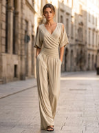 Driftly khaki crossed V-neck wrap jumpsuit with kimono style wide sleeves and a ruched waist, on a European street at golden hour.