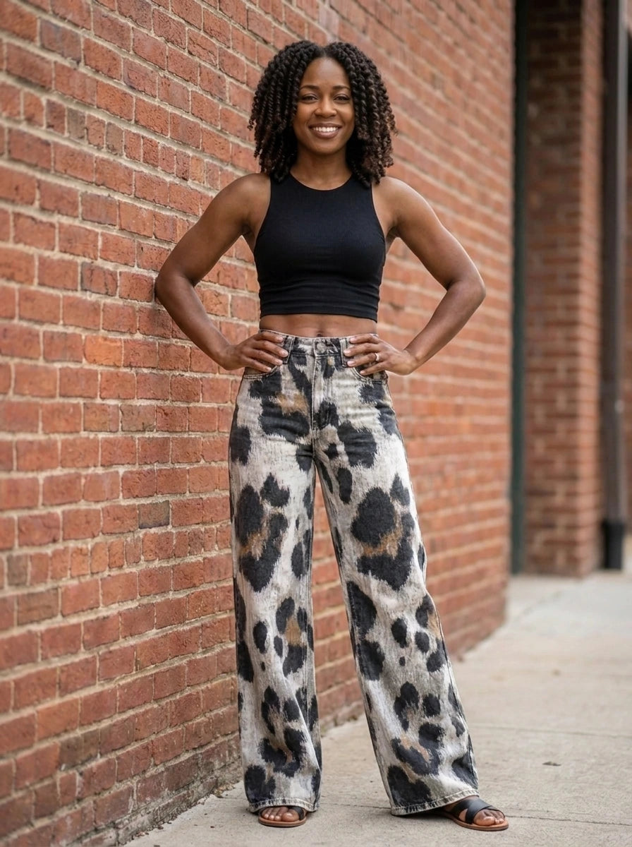 Woman wearing black-white cheetah print bohemian pants, different pose against a brick wall