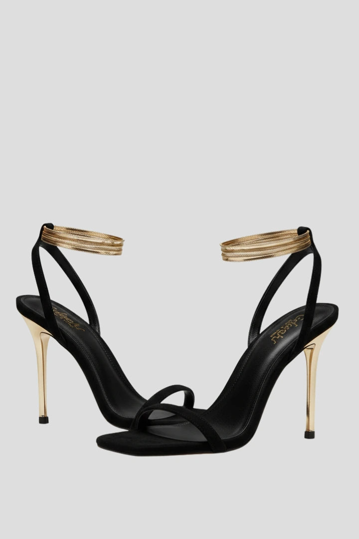 Woman wearing black heeled thin strap wrap-around ankle sandals - lifestyle photo