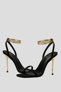 Woman wearing black heeled thin strap wrap-around ankle sandals - lifestyle photo