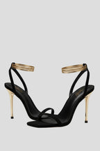 Woman wearing black heeled thin strap wrap-around ankle sandals - lifestyle photo