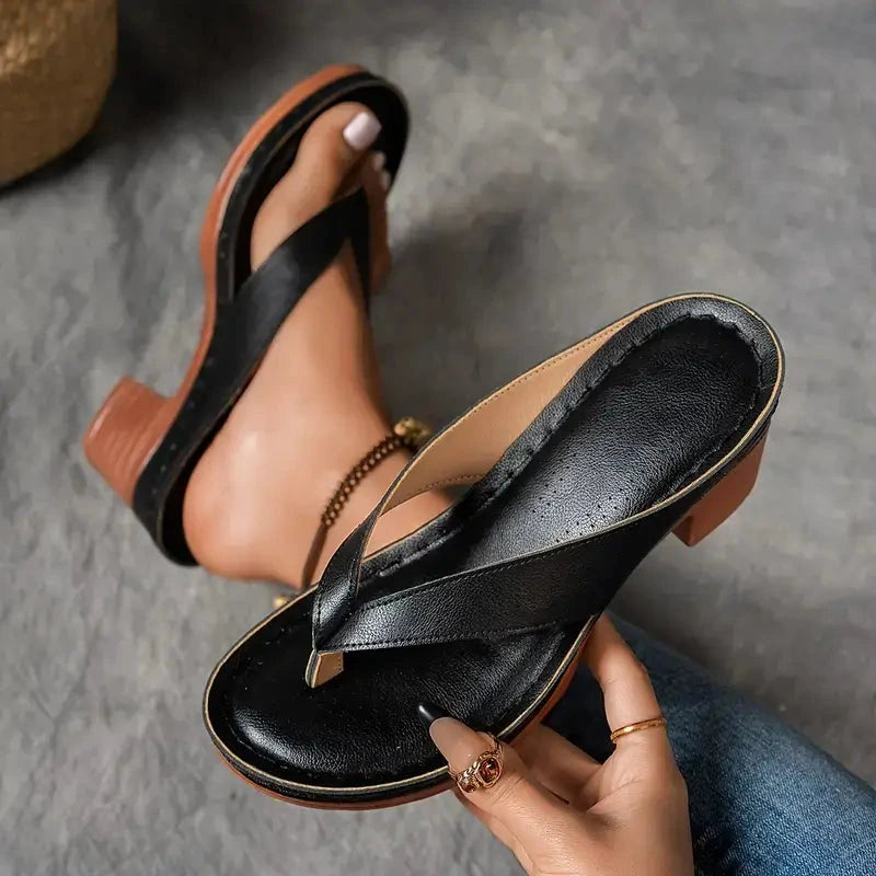 Woman wearing a black heeled thong orthopedic sandals - studio photo
