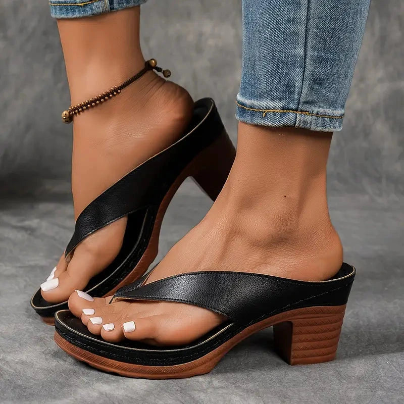 Woman wearing a brown heeled thong orthopedic sandals - studio photo