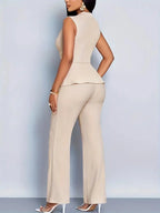 Woman wearing a beige sleeveless top trousers set - studio photo
