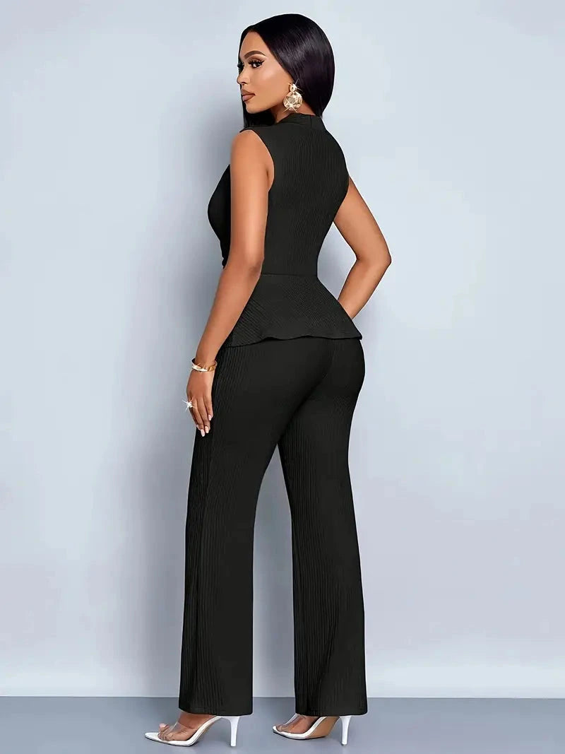 Woman wearing a black sleeveless top trousers set - studio photo
