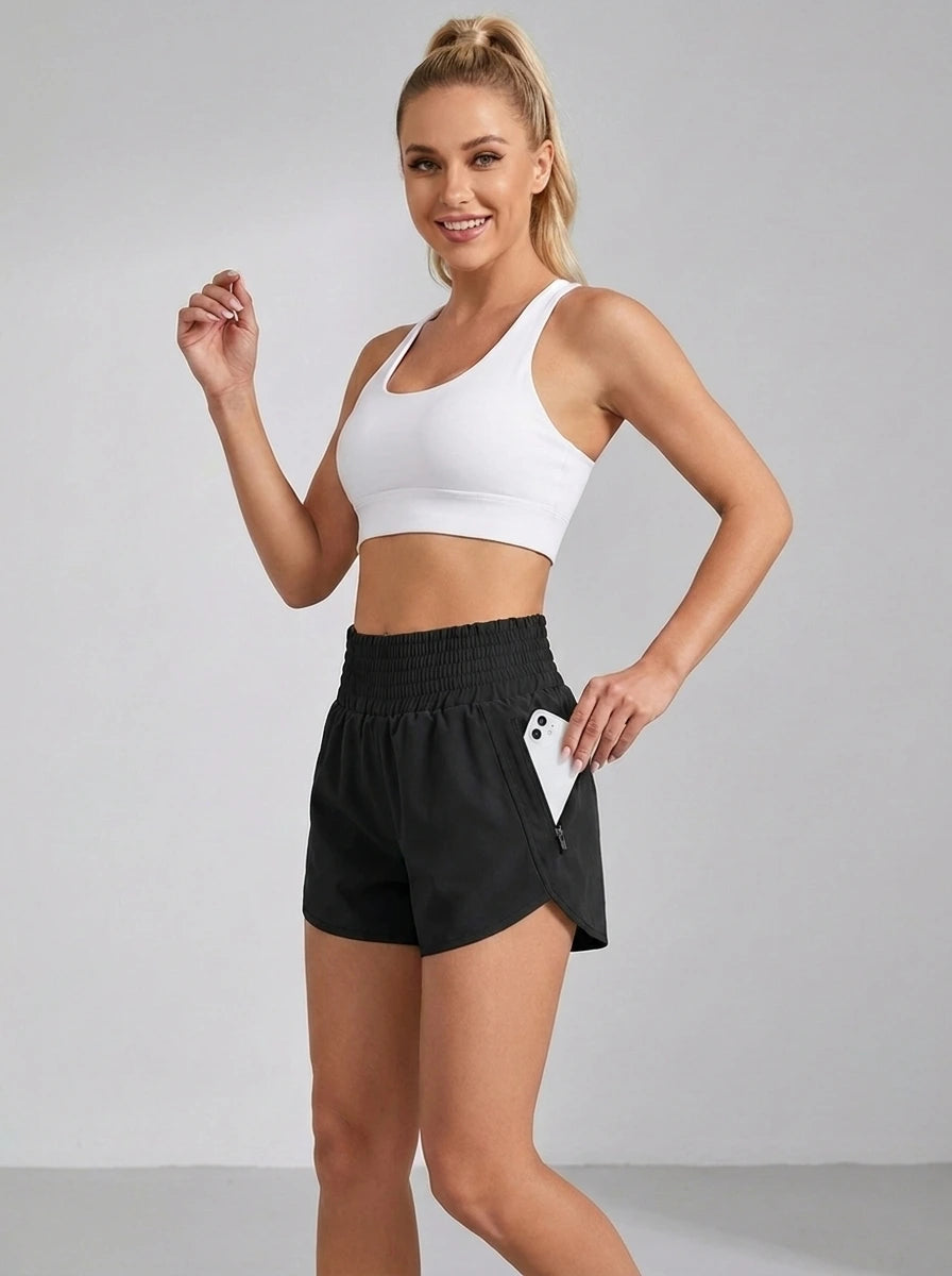 Black running yoga shorts with ruched waistband and zippered side pocket, studio front view.