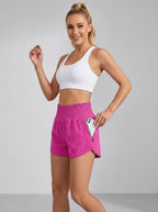 Pink running yoga shorts with ruched waistband and zippered side pocket, studio front view.