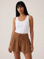 Brown high-waist drawstring shorts with shirred waistband, relaxed fit, studio front view.