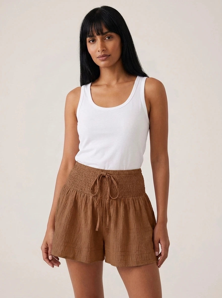 Brown high-waist drawstring shorts with shirred waistband, relaxed fit, studio front view.
