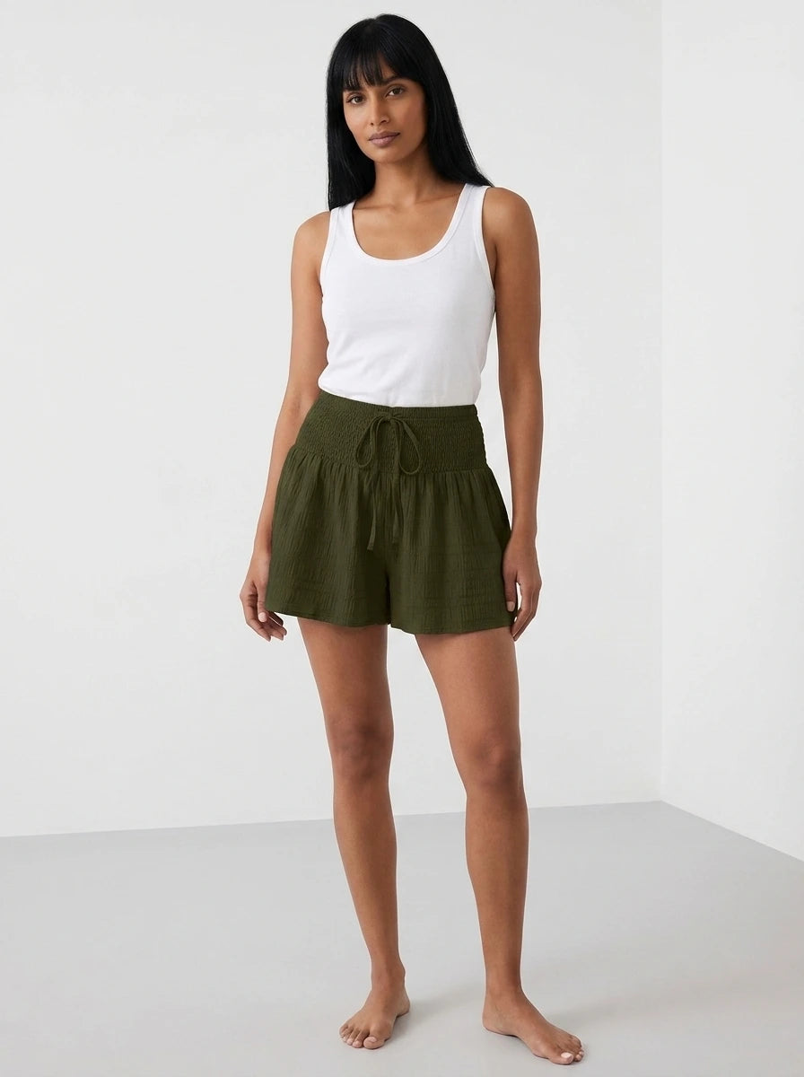 Dark green high-waist drawstring shorts with shirred waistband, relaxed fit, studio front view.