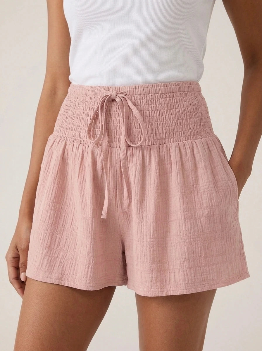Close-up of pink high-waist drawstring shorts showing shirred waistband and drawstring.