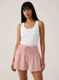 Pink high-waist drawstring shorts with shirred waistband, relaxed fit, studio front view.