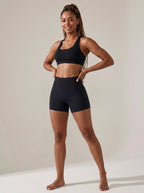 Black high-waisted yoga shorts, ribbed waistband, studio front view.