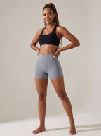 Gray high-waisted yoga shorts, slim fit, soft stretchy fabric, studio front view.