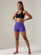 Purple high-waisted yoga shorts, slim fit, soft stretchy fabric, studio front view.