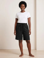 Black lightweight casual summer shorts with elastic waistband and relaxed fit, studio front view.