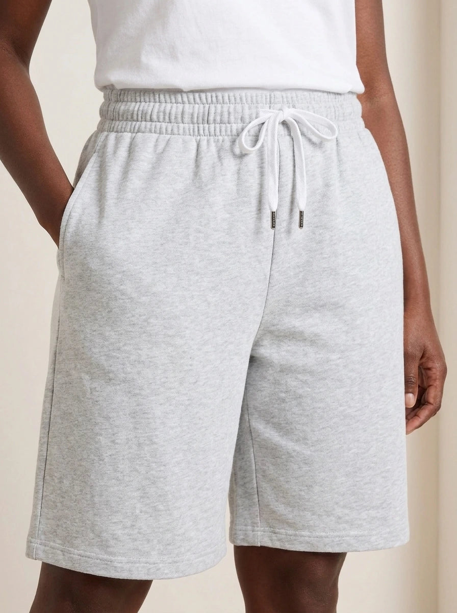 Close-up of gray lightweight summer shorts showing elastic waistband, drawstring, and pockets.