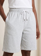 Close-up of gray lightweight summer shorts showing elastic waistband, drawstring, and pockets.