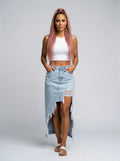 Woman wearing a light blue distressed denim midi skirt in a studio setting