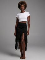 Woman wearing a black suede fringe ruffle split midi skirt in a studio setting