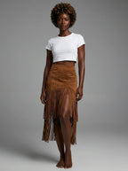 Woman wearing a brown suede fringe ruffle split midi skirt in a studio setting