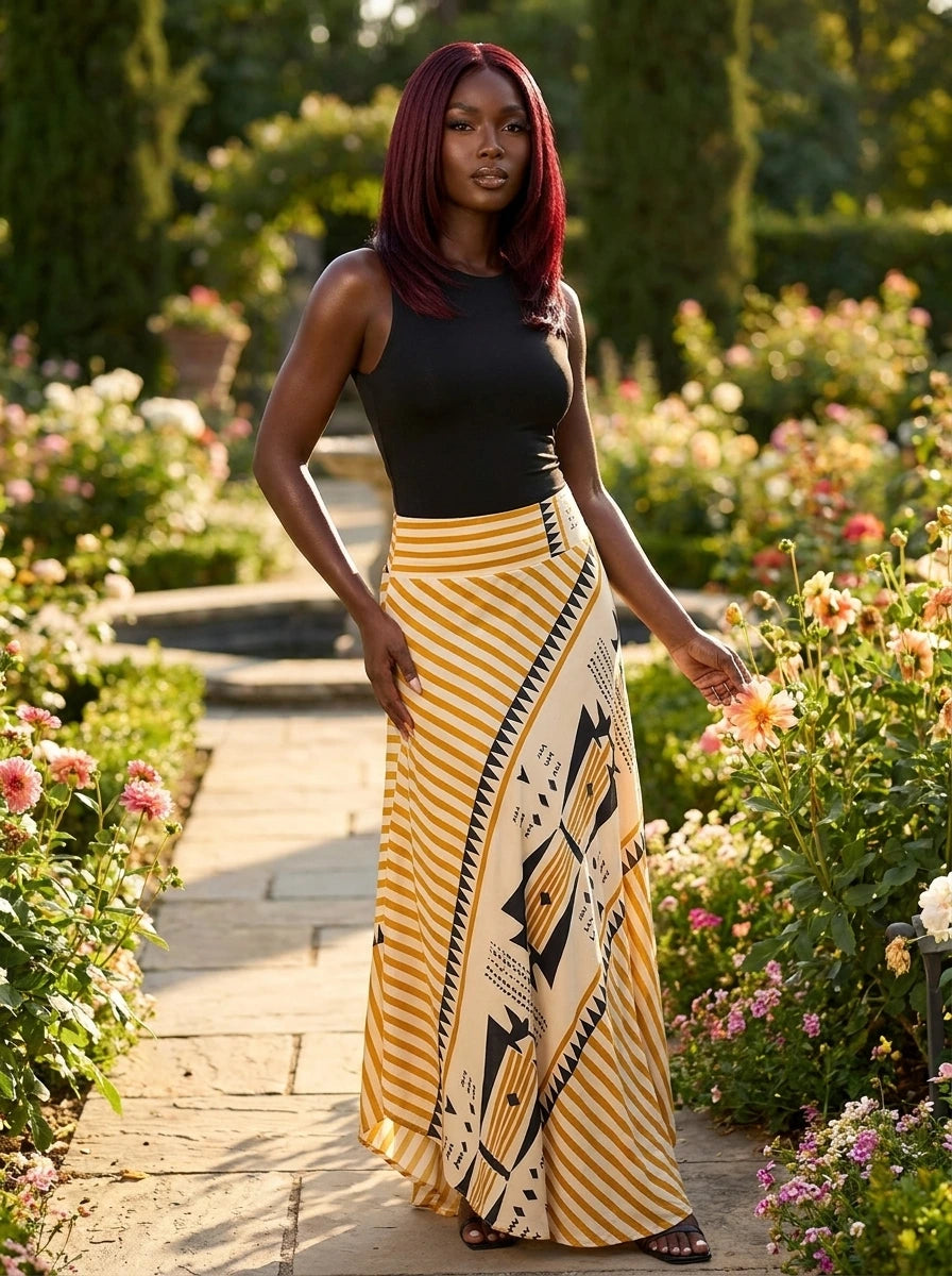 Woman wearing a yellow geometric print satin maxi skirt in a garden setting