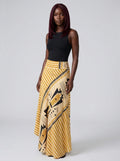 Woman wearing a yellow geometric print satin maxi skirt in a studio setting