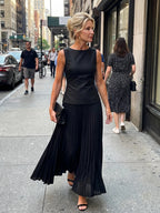 Woman wearing a black structured bodice pleated skirt set - editorial style photo